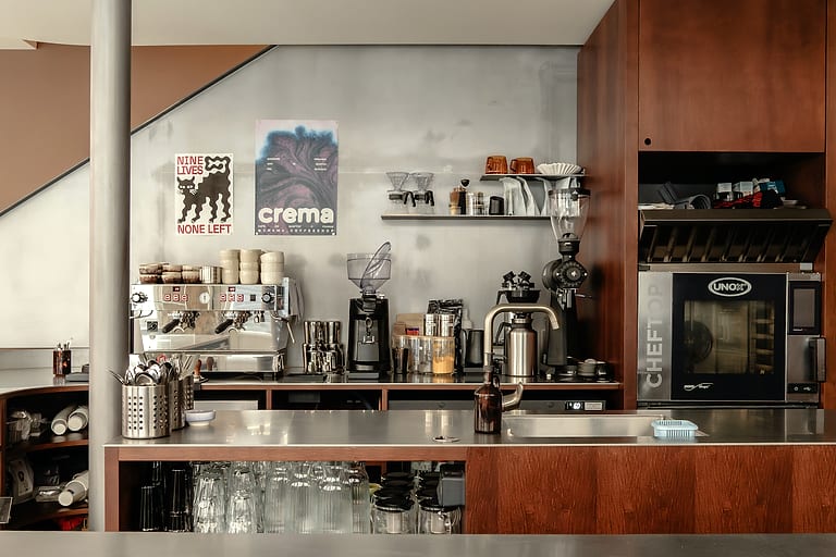 Le bar vu de face, la machine à espresso, les moulins et les boiseries sombres.