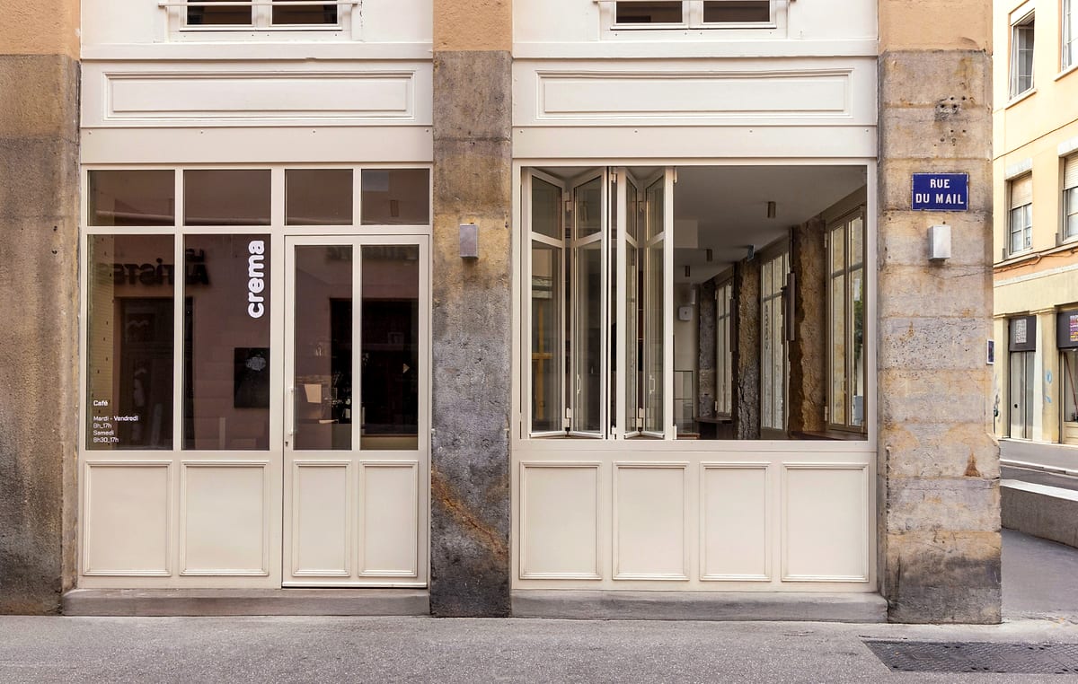 La devanture couleur crème de Crema, le nom peint en bas de casse sur la vitre, rue du Mail.
