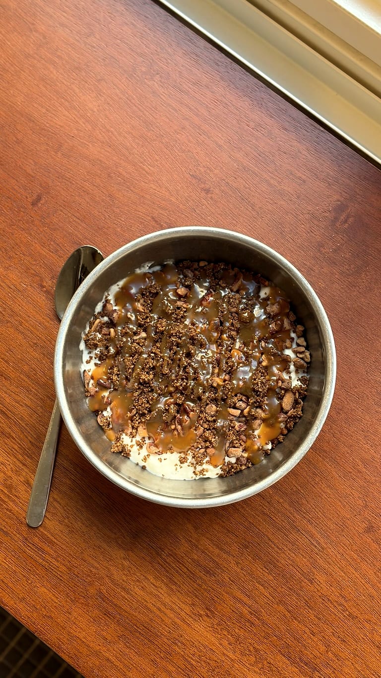 Un bol de granola au caramel, vu de dessus sur la table de bois.