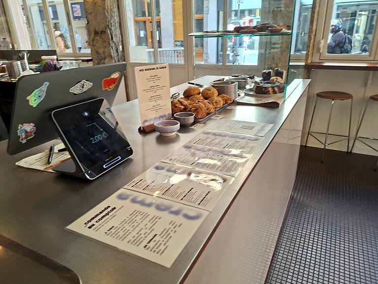 Le comptoir en inox, la vitrine des pâtisseries et la carte du jour.